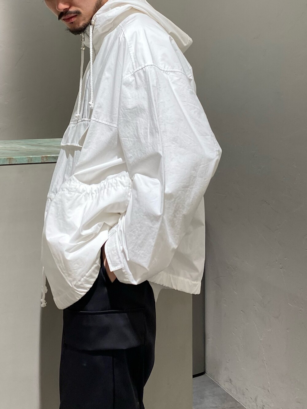 ホワイト系のマウンテンパーカー、ブラック系のカーゴパンツを着用したメンズの春コーディネートの3枚目の写真