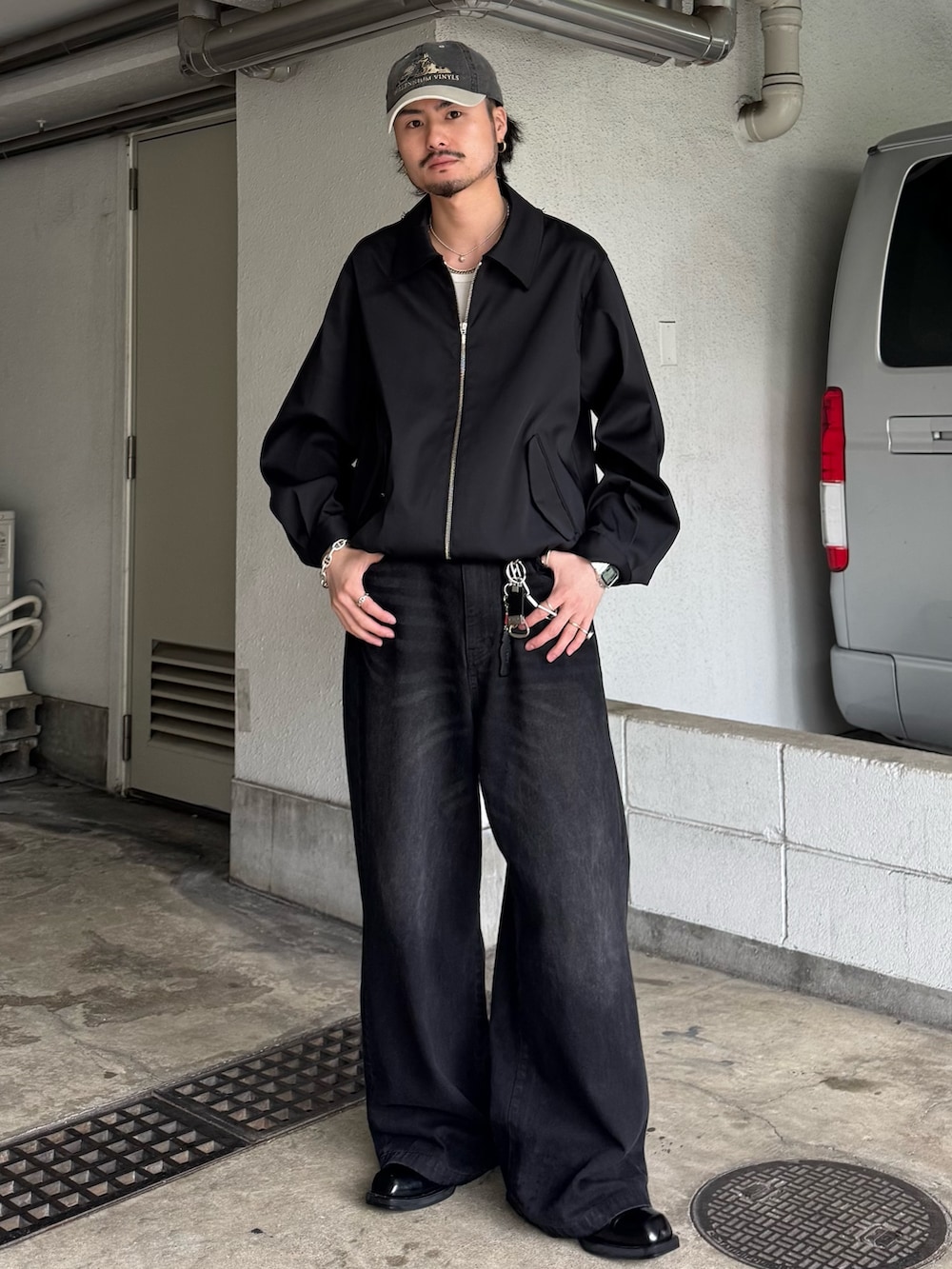 ブラック系のブルゾン、ブラック系のデニムパンツを着用したメンズの夏コーディネートの2枚目の写真