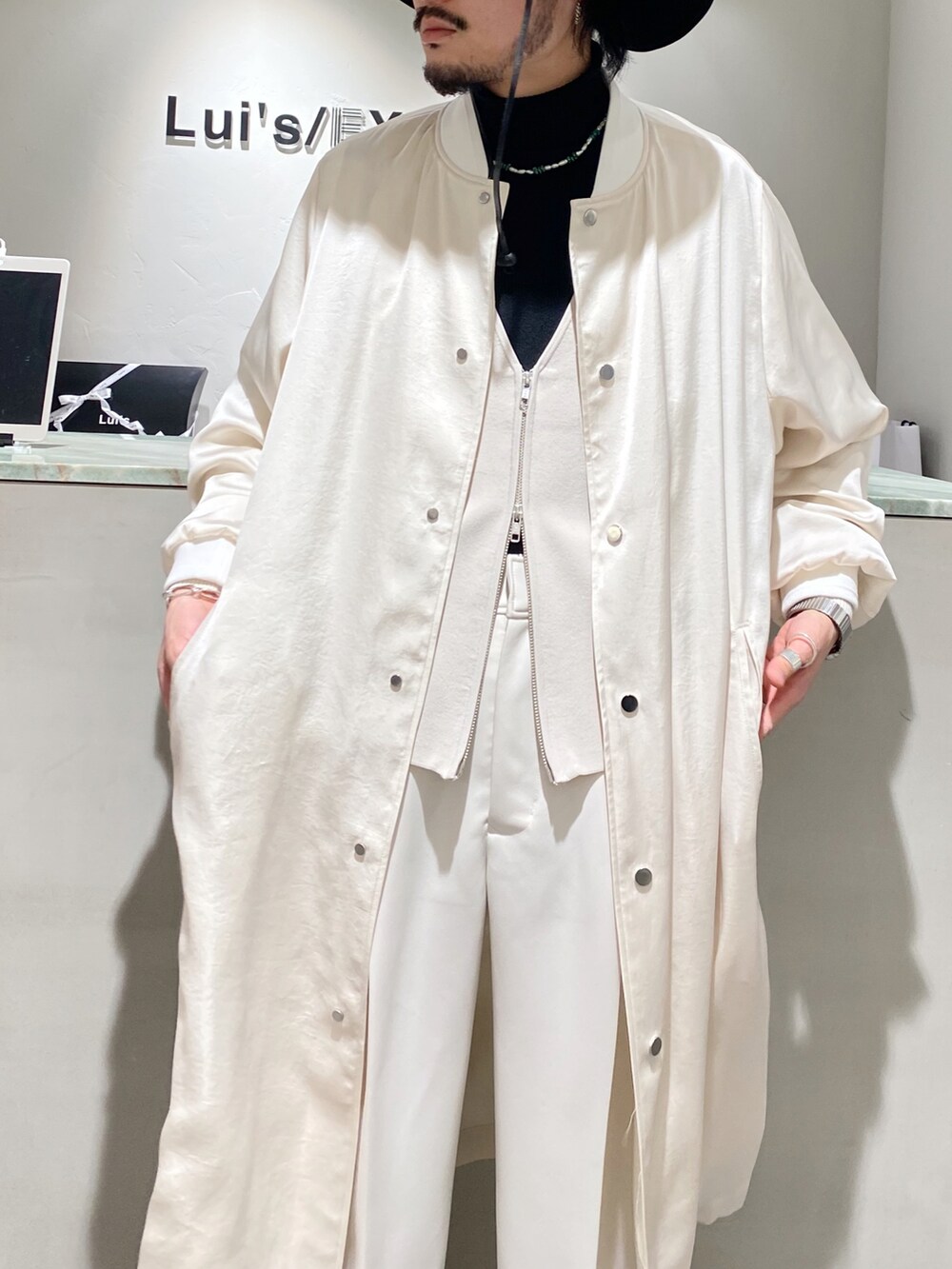 ホワイト系のブルゾン、ホワイト系のカーディガン/ボレロ、ホワイト系のスラックスを着用したメンズの冬コーディネートの4枚目の写真