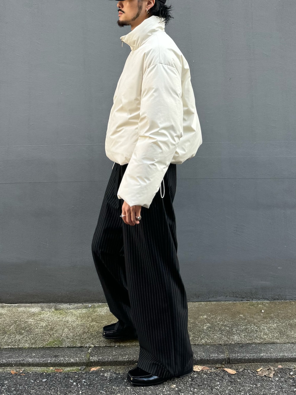 ホワイト系のブルゾン、ブラック系のその他パンツ、ブラック系のローファーを着用したメンズの冬コーディネートの4枚目の写真