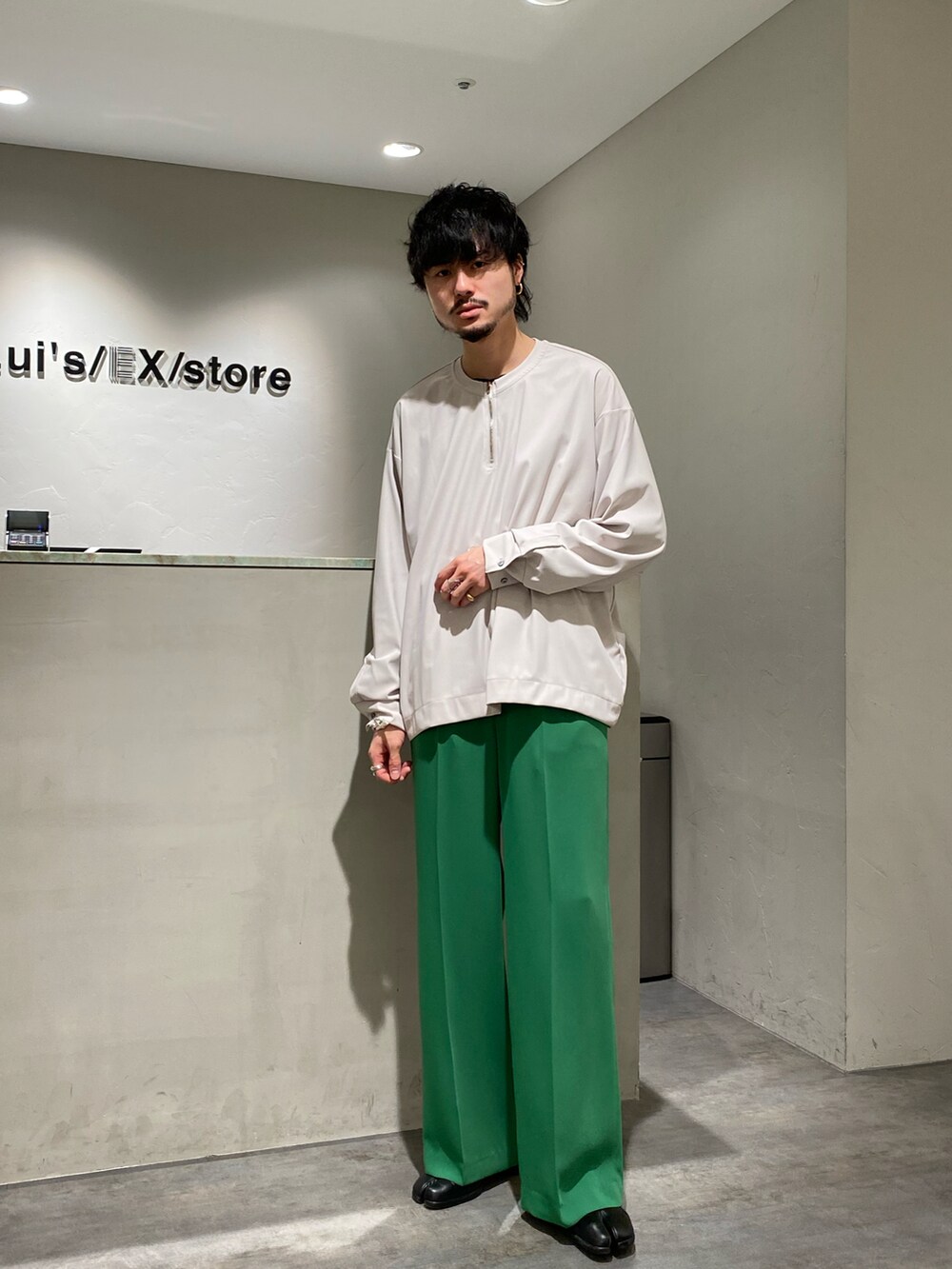 グレー系のTシャツ/カットソー、グリーン系のスラックスを着用したメンズの春コーディネートの2枚目の写真