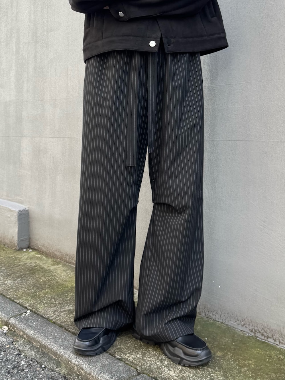 ブラック系のブルゾン、ブラック系のその他パンツ、ブラック系のローファーを着用したメンズの冬コーディネートの5枚目の写真