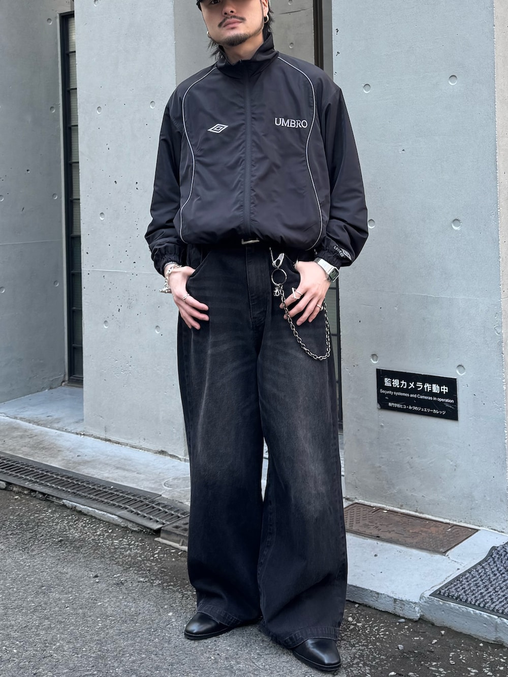 ブラック系のデニムパンツ、ブラック系のその他シューズ、ブラック系のブルゾンを着用したメンズの春コーディネートの2枚目の写真