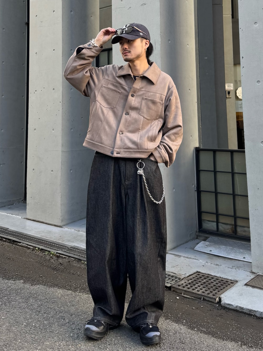 グレー系のブルゾン、ブルー系のニット/セーター、ブラック系のデニムパンツを着用したメンズの冬コーディネートの2枚目の写真