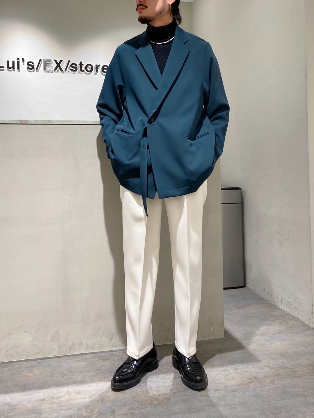 グリーン系のテーラードジャケット、ホワイト系のカーディガン/ボレロ、ホワイト系のスラックスを着用したメンズの春コーディネートの3枚目の写真