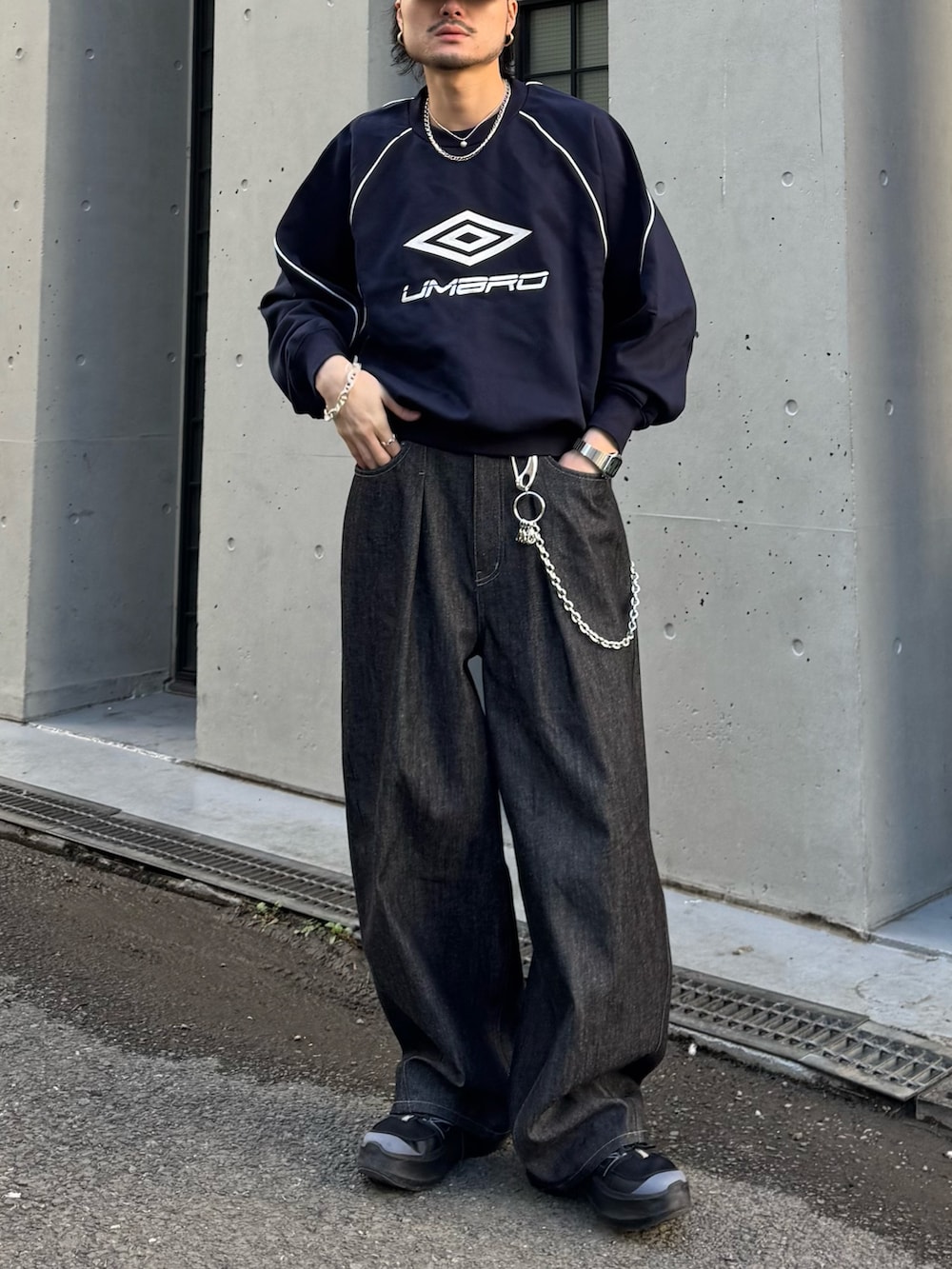 ブルー系のスウェット、ブラック系のデニムパンツを着用したメンズの冬コーディネートの5枚目の写真