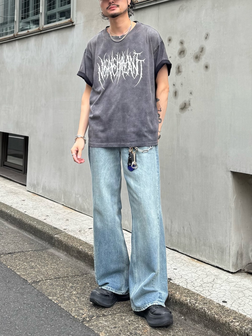 ブラック系のTシャツ/カットソー、ブルー系のデニムパンツを着用したメンズの夏コーディネートの3枚目の写真