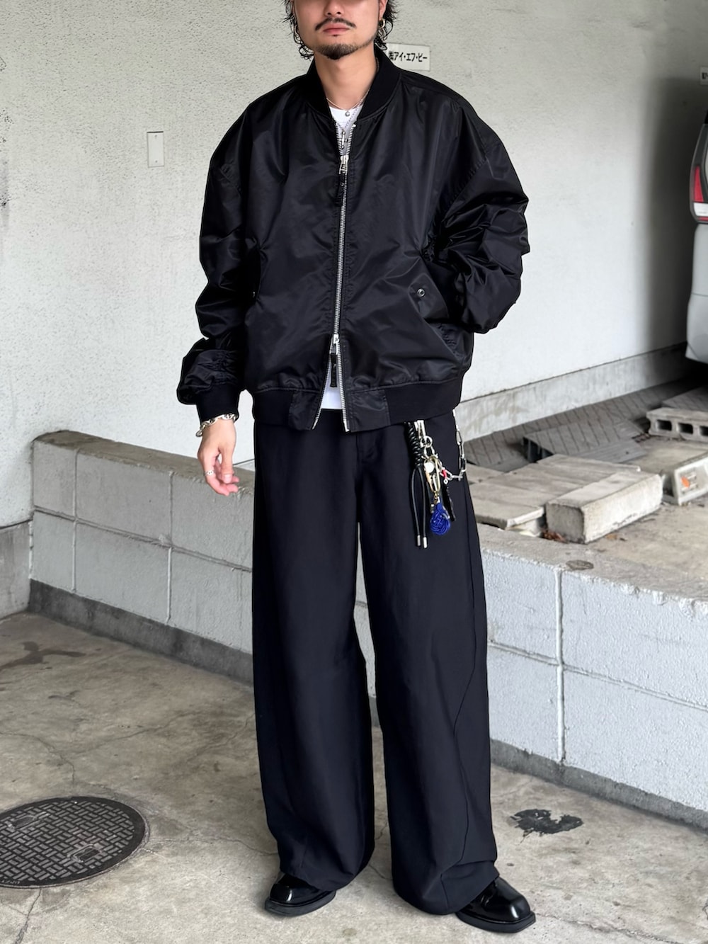 ブラック系のMA-1、ブラック系のスラックスを着用したメンズの秋コーディネートの3枚目の写真