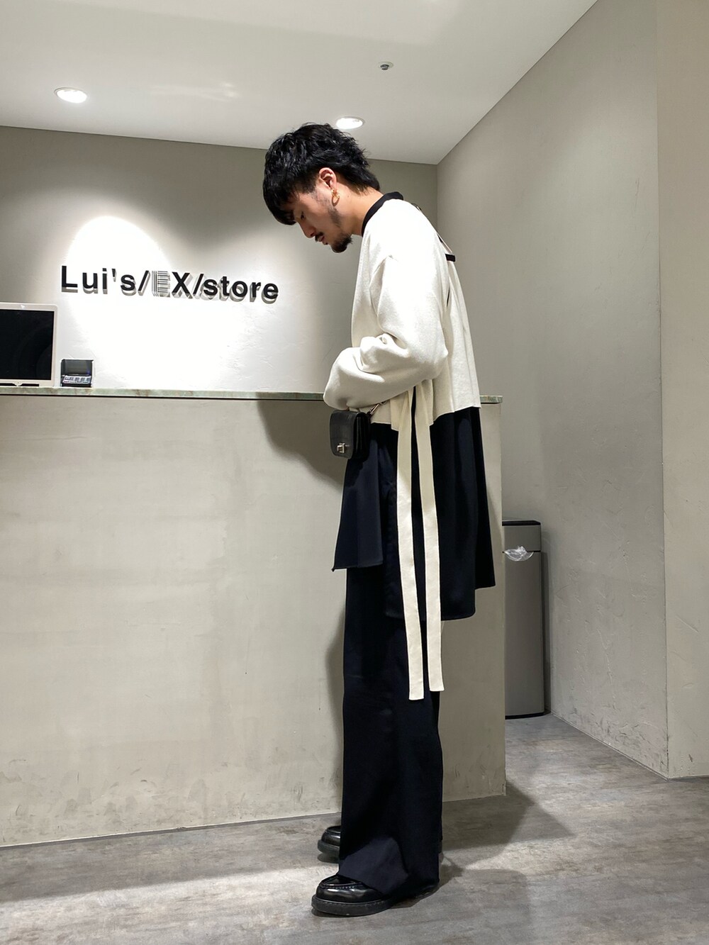 ベージュ系のトップス、ブラック系のシャツ/ブラウス、ブラック系のスラックスを着用したメンズの春コーディネートの2枚目の写真