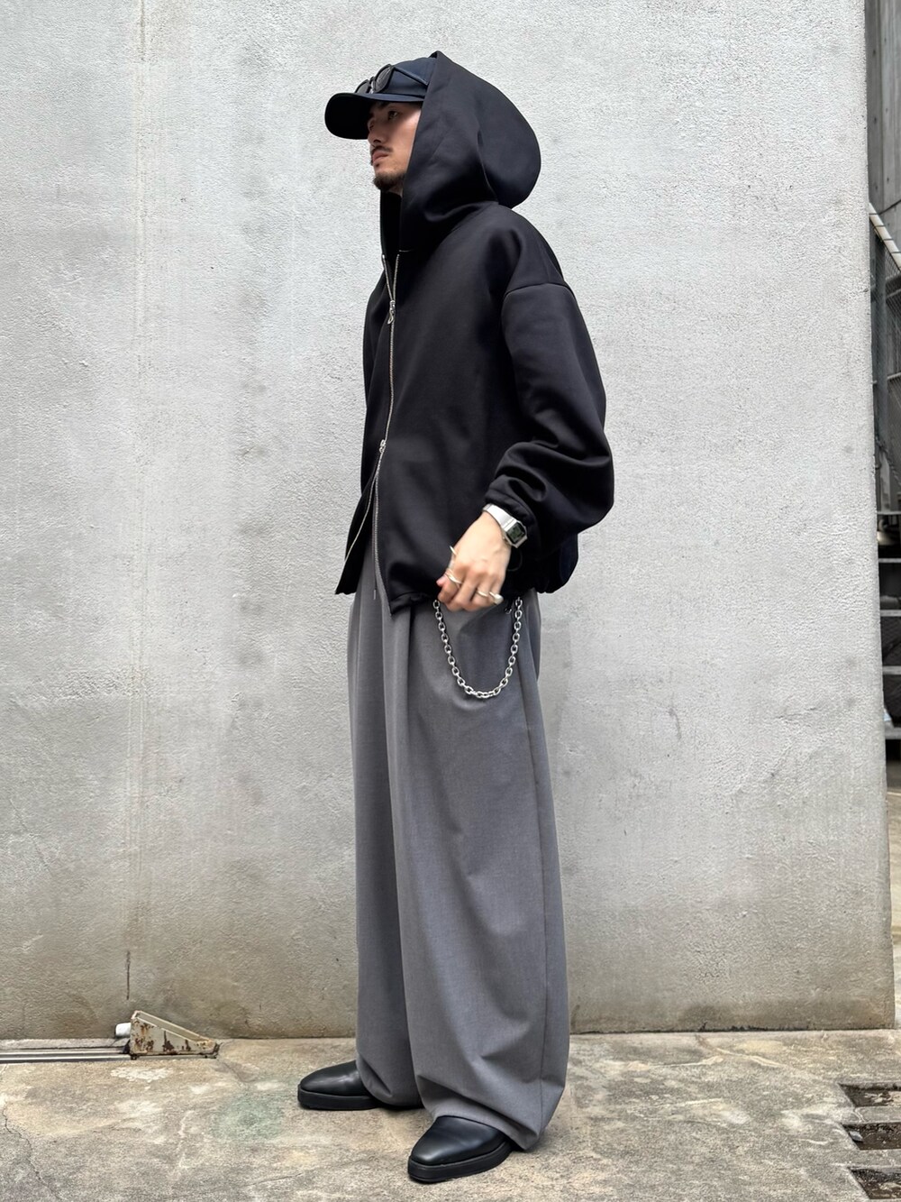 ブラック系のパーカー、グレー系のスラックス、シルバー系のウォレットチェーンを着用したメンズの秋コーディネートの4枚目の写真