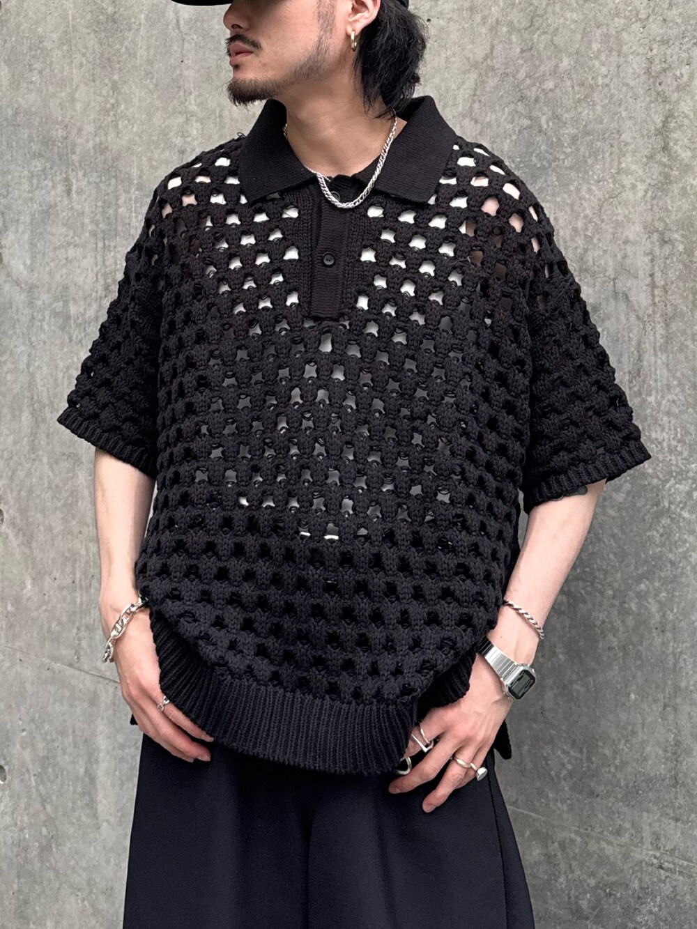 ブラック系のニット/セーター、ブラック系のスラックスを着用したメンズの春コーディネートの3枚目の写真