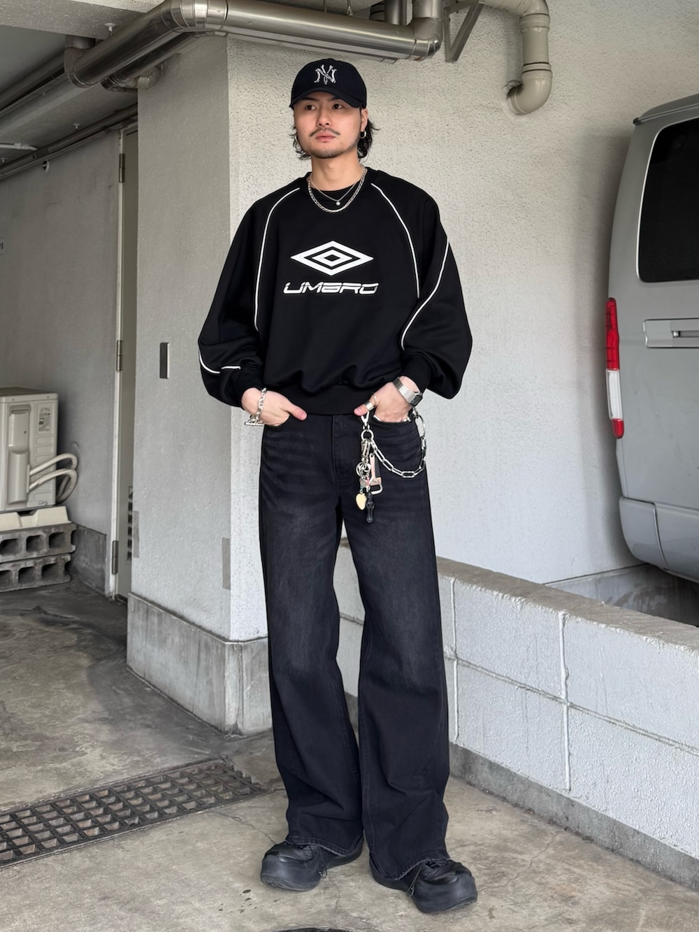 ブラック系のスウェット、ブラック系のデニムパンツを着用したメンズの春コーディネートの2枚目の写真