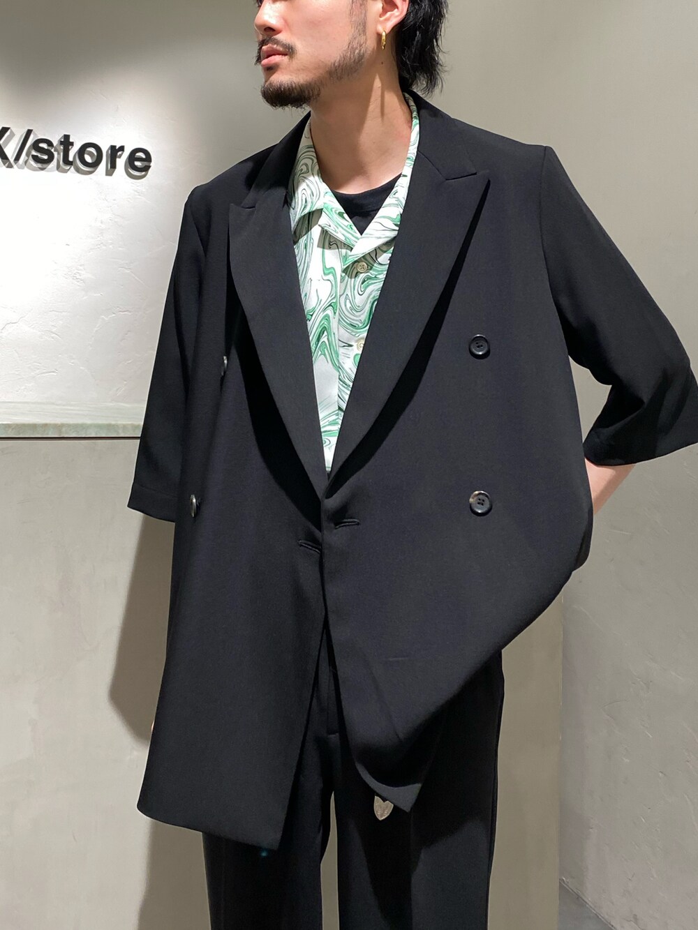 ブラック系のテーラードジャケット、グリーン系のシャツ/ブラウス、ブラック系のスラックスを着用したメンズの春コーディネートの2枚目の写真