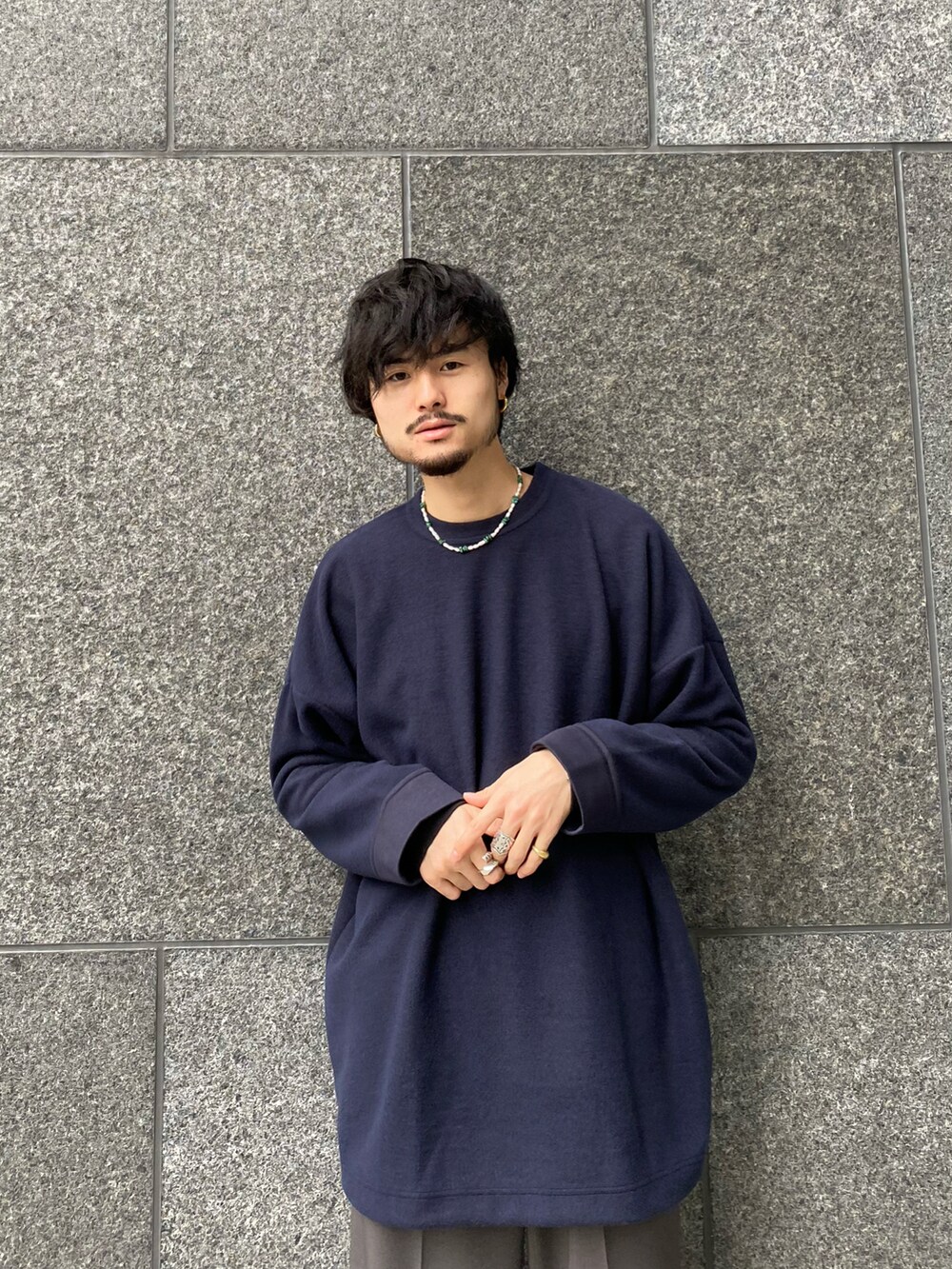 ブルー系のTシャツ/カットソー、グレー系のスラックス、ブラック系のドレスシューズを着用したメンズの冬コーディネートの4枚目の写真