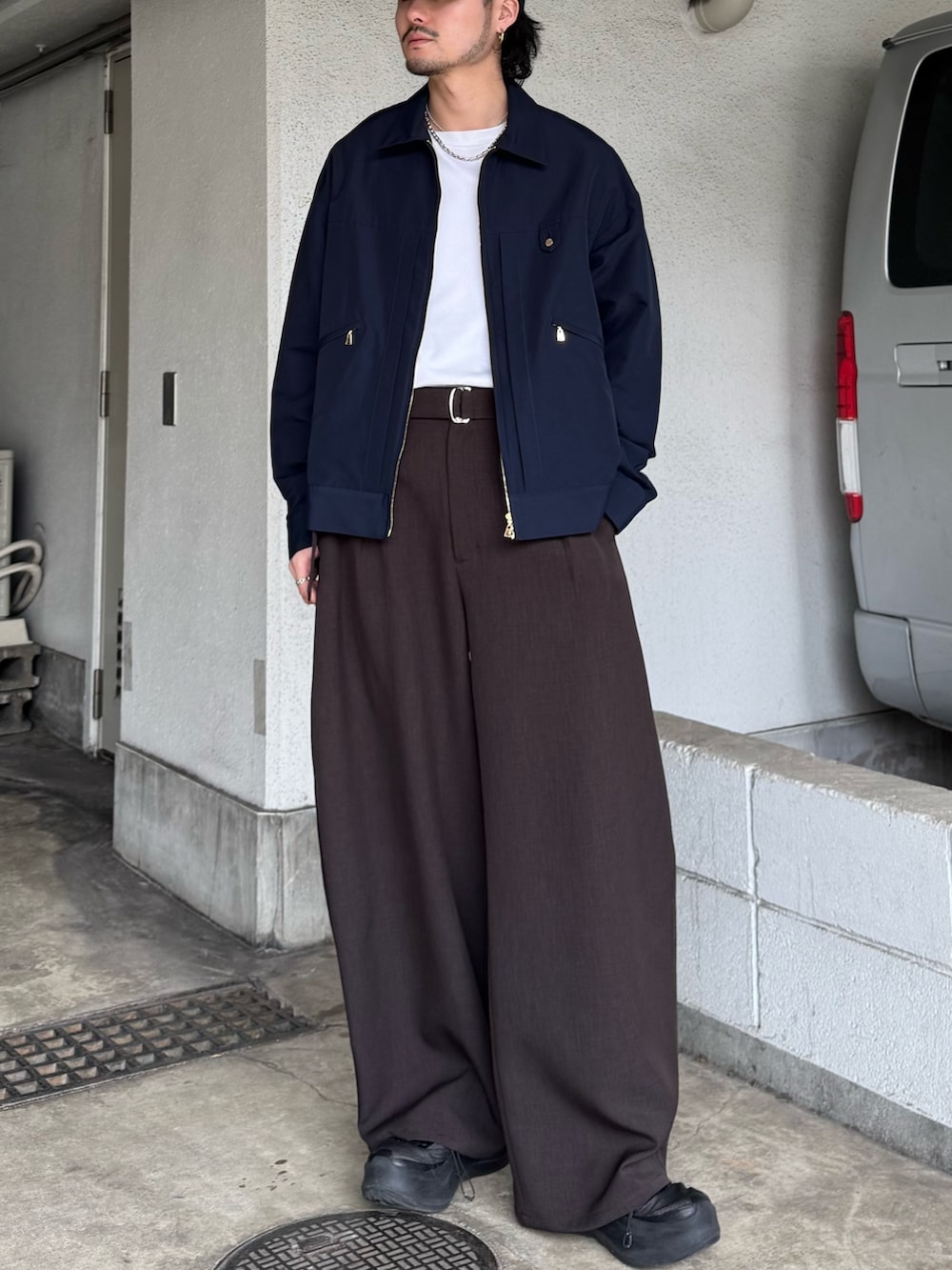ブルー系のブルゾン、グレー系のスラックスを着用したメンズの春コーディネートの3枚目の写真