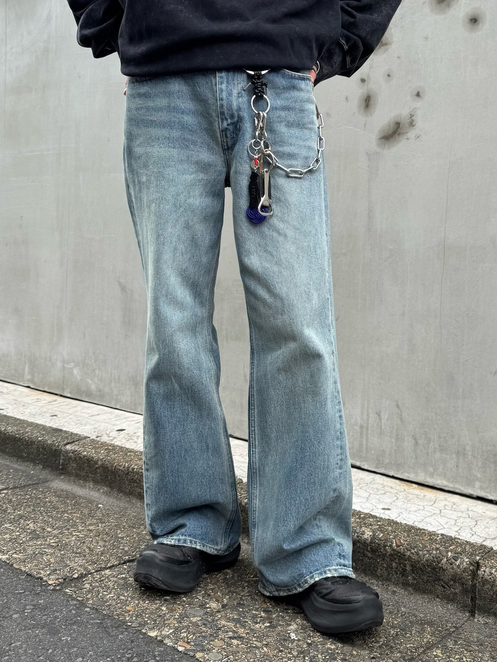 ブラック系のスウェット、ブルー系のデニムパンツを着用したメンズの夏コーディネートの4枚目の写真