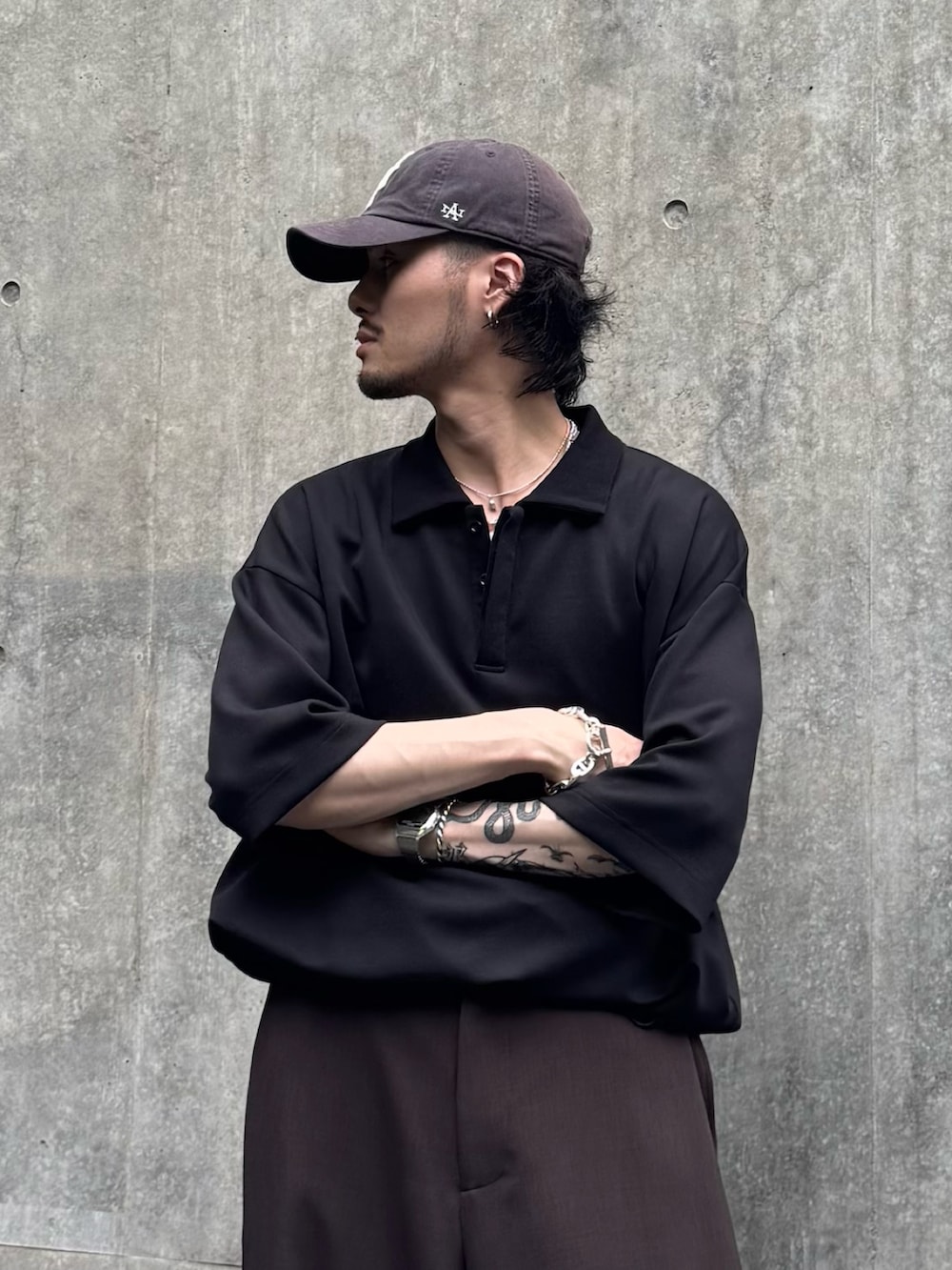 ブラック系のTシャツ/カットソー、ブラウン系のスラックスを着用したメンズの夏コーディネートの3枚目の写真