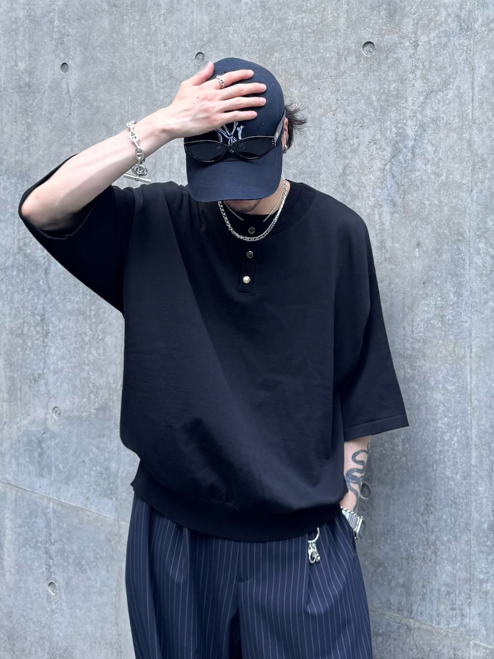 ブラック系のTシャツ/カットソー、ブルー系のスラックス、ブラック系のその他シューズを着用したメンズの夏コーディネートの3枚目の写真