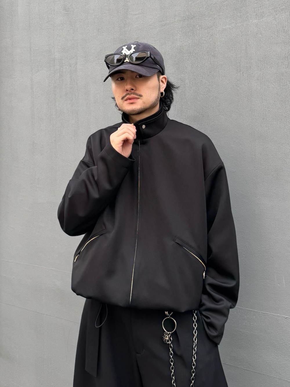 ブラック系のブルゾン、ブラック系のスラックス、ブラック系のウォレットチェーンを着用したメンズの春コーディネートの4枚目の写真