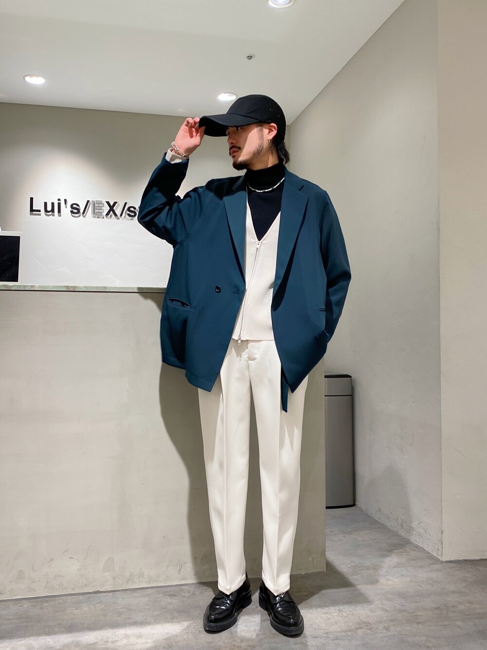 グリーン系のテーラードジャケット、ホワイト系のカーディガン/ボレロ、ホワイト系のスラックスを着用したメンズの春コーディネートの2枚目の写真