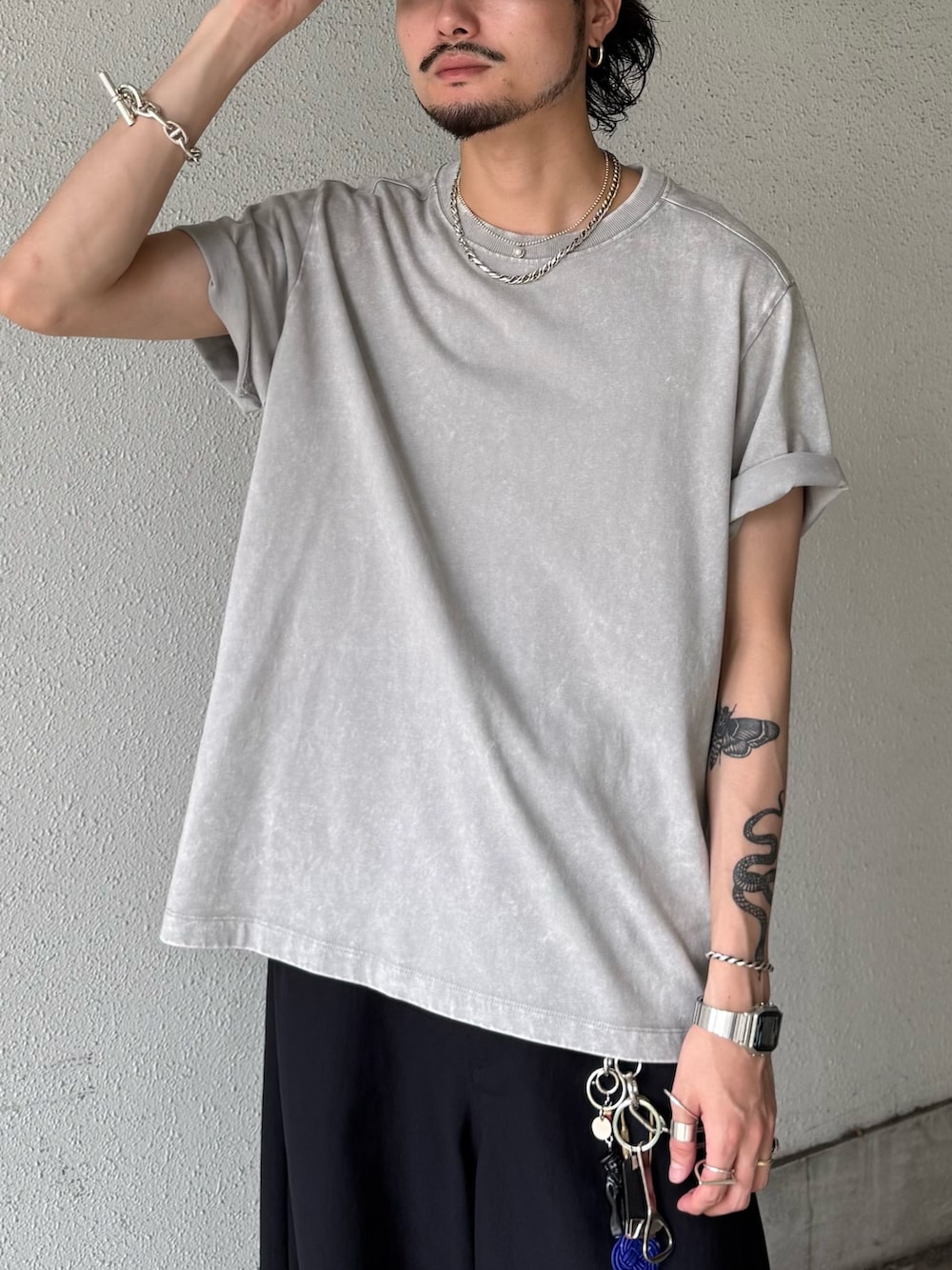 グレー系のTシャツ/カットソー、ブラック系のスラックスを着用したメンズの夏コーディネートの3枚目の写真