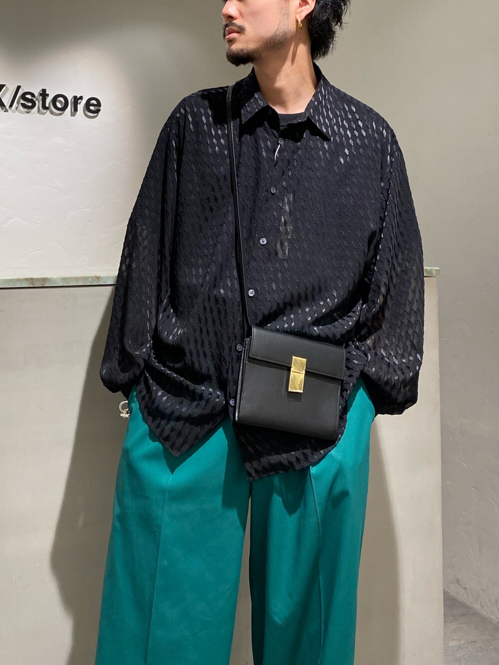 ブラック系のシャツ/ブラウス、ブラック系のショルダーバッグ、グリーン系のスラックスを着用したメンズの春コーディネートの3枚目の写真