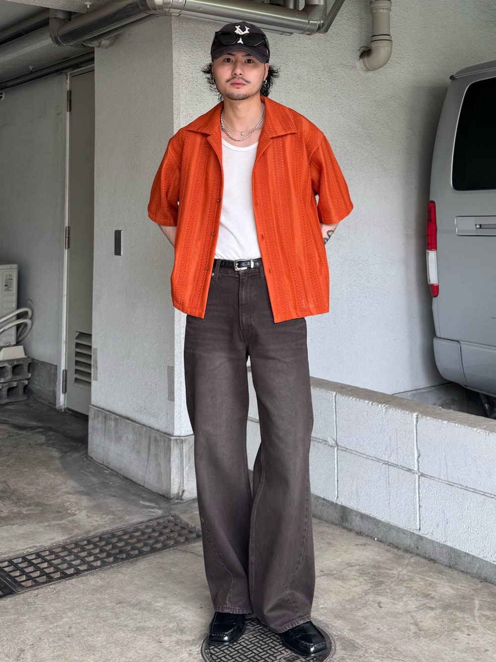 オレンジ系のシャツ/ブラウス、ブラウン系のデニムパンツを着用したメンズの夏コーディネートの2枚目の写真