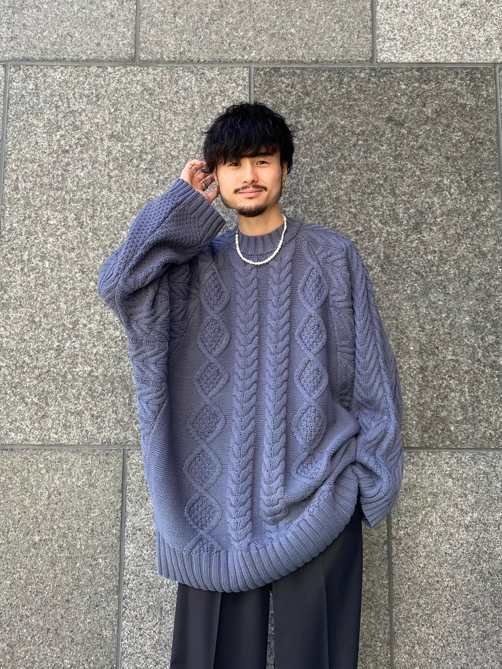 ブルー系のニット/セーター、ブラック系のスラックス、ブラック系の財布を着用したメンズの秋コーディネートの5枚目の写真