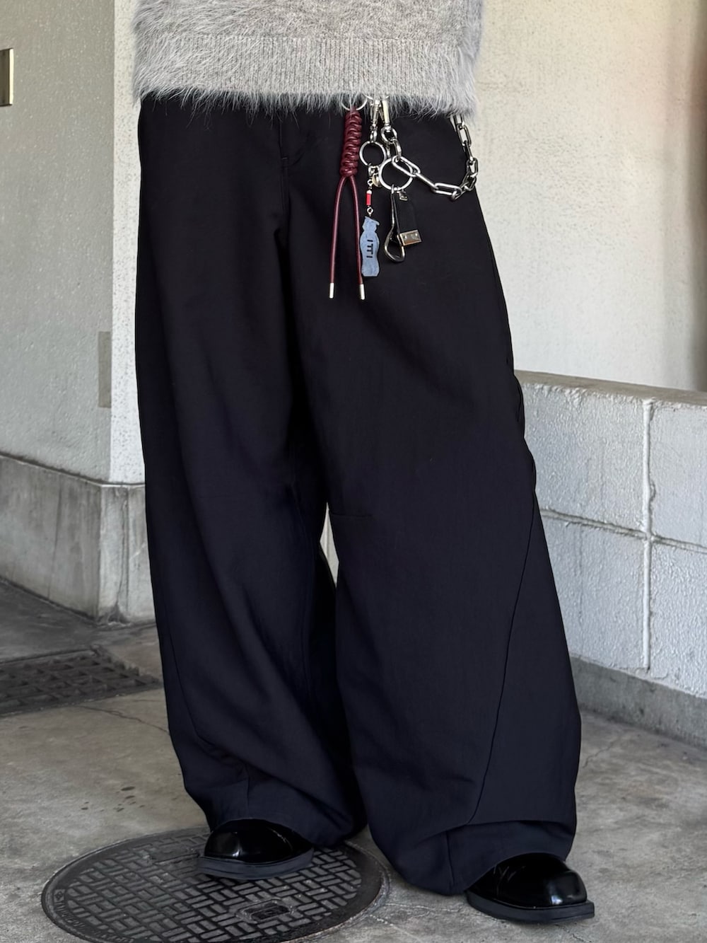 ブラック系のスラックス、グレー系のブルゾン、グレー系のニット/セーターを着用したメンズの秋コーディネートの6枚目の写真