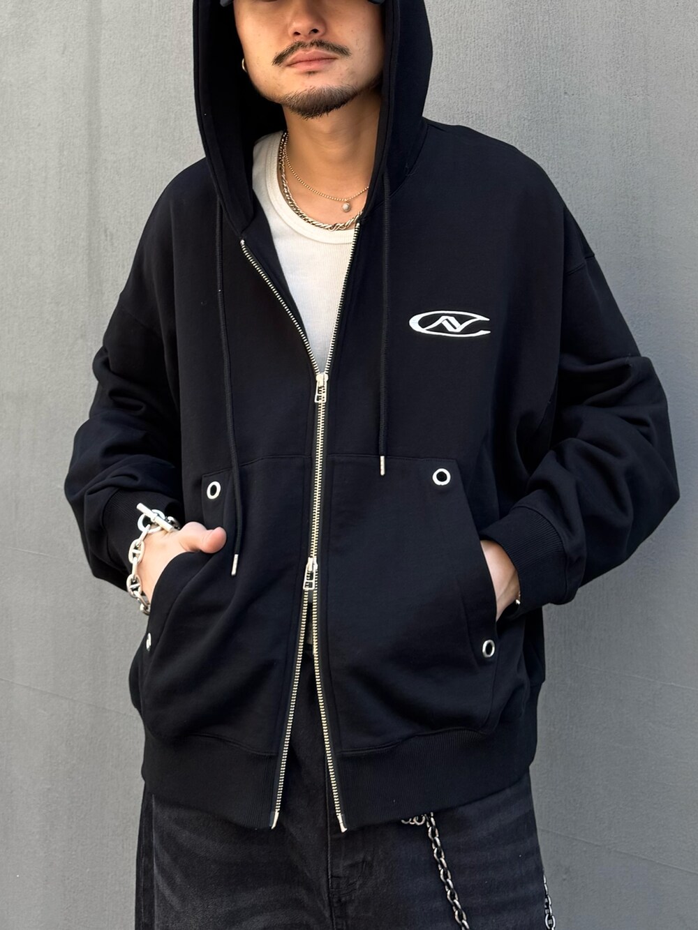 ブラック系のパーカー、ホワイト系のタンクトップ、ブラック系のその他シューズを着用したメンズの春コーディネートの3枚目の写真