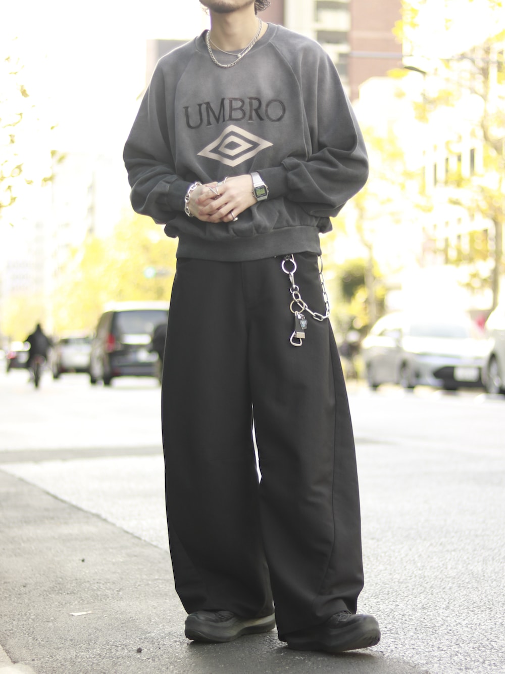 グレー系のスウェット、ブラック系のスラックス、ブラック系のキーホルダーを着用したメンズの冬コーディネートの5枚目の写真