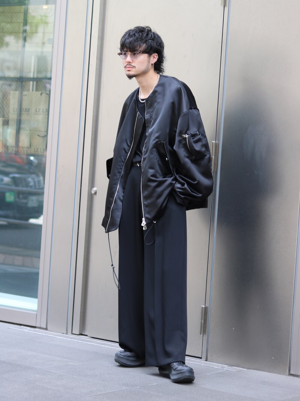 ブラック系のブルゾン、ブラック系のスラックスを着用したメンズの夏コーディネートの3枚目の写真