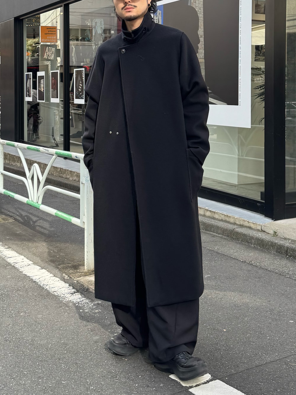 ブラック系のその他アウター、ブルー系のニット/セーター、ブラック系のスラックスを着用したメンズの冬コーディネートの3枚目の写真