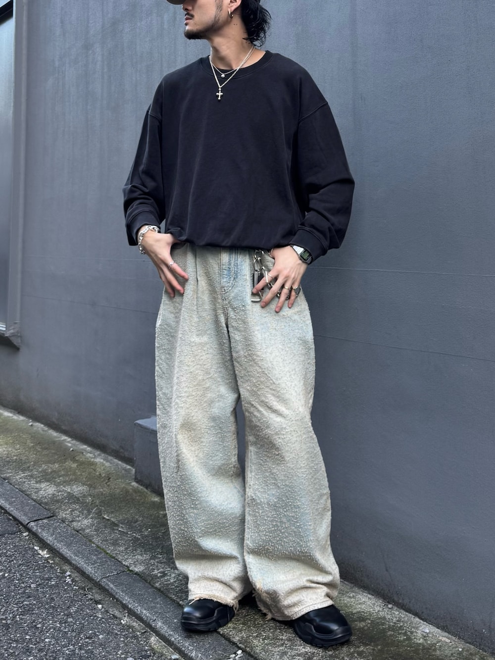 ブラック系のスウェット、ブラック系のその他シューズ、ブルー系のデニムパンツを着用したメンズの秋コーディネートの3枚目の写真