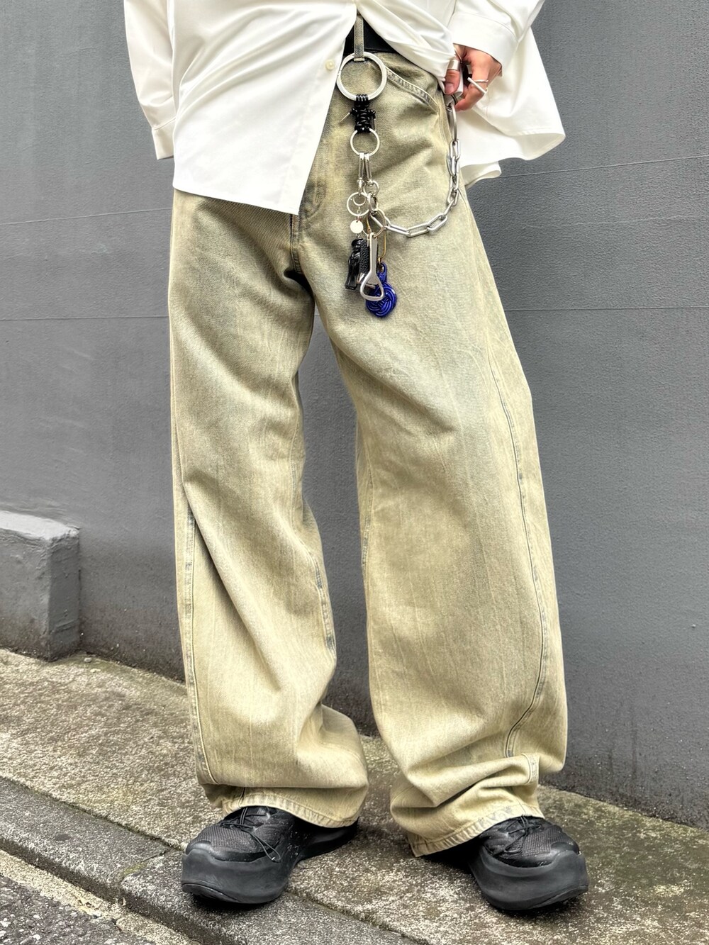 ホワイト系のトップス、グリーン系のデニムパンツを着用したメンズの夏コーディネートの5枚目の写真