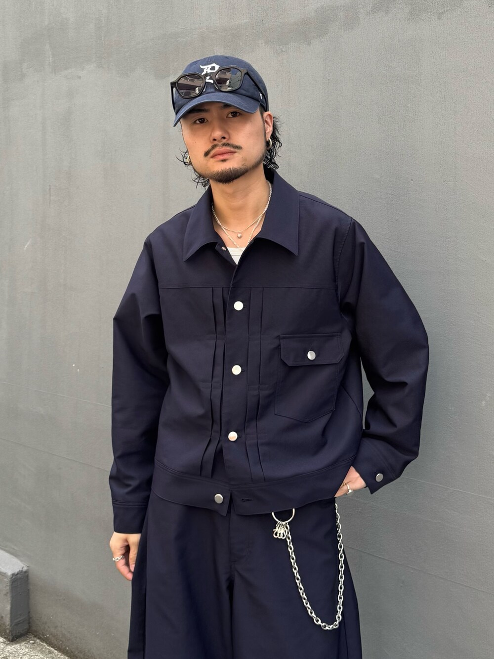 ブルー系のブルゾン、ブルー系のスラックス、シルバー系のウォレットチェーンを着用したメンズの夏コーディネートの6枚目の写真
