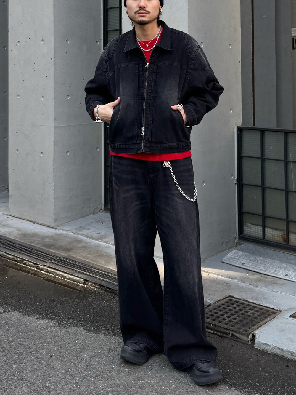 ブラック系のブルゾン、ブラック系のデニムパンツ、レッド系のニット/セーターを着用したメンズの冬コーディネートの2枚目の写真