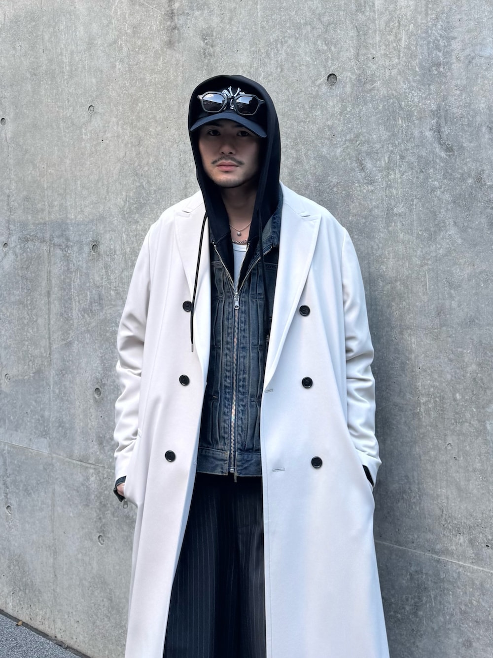 グレー系のチェスターコート、ブルー系のデニムジャケット、ブラック系のパーカーを着用したメンズの冬コーディネートの6枚目の写真