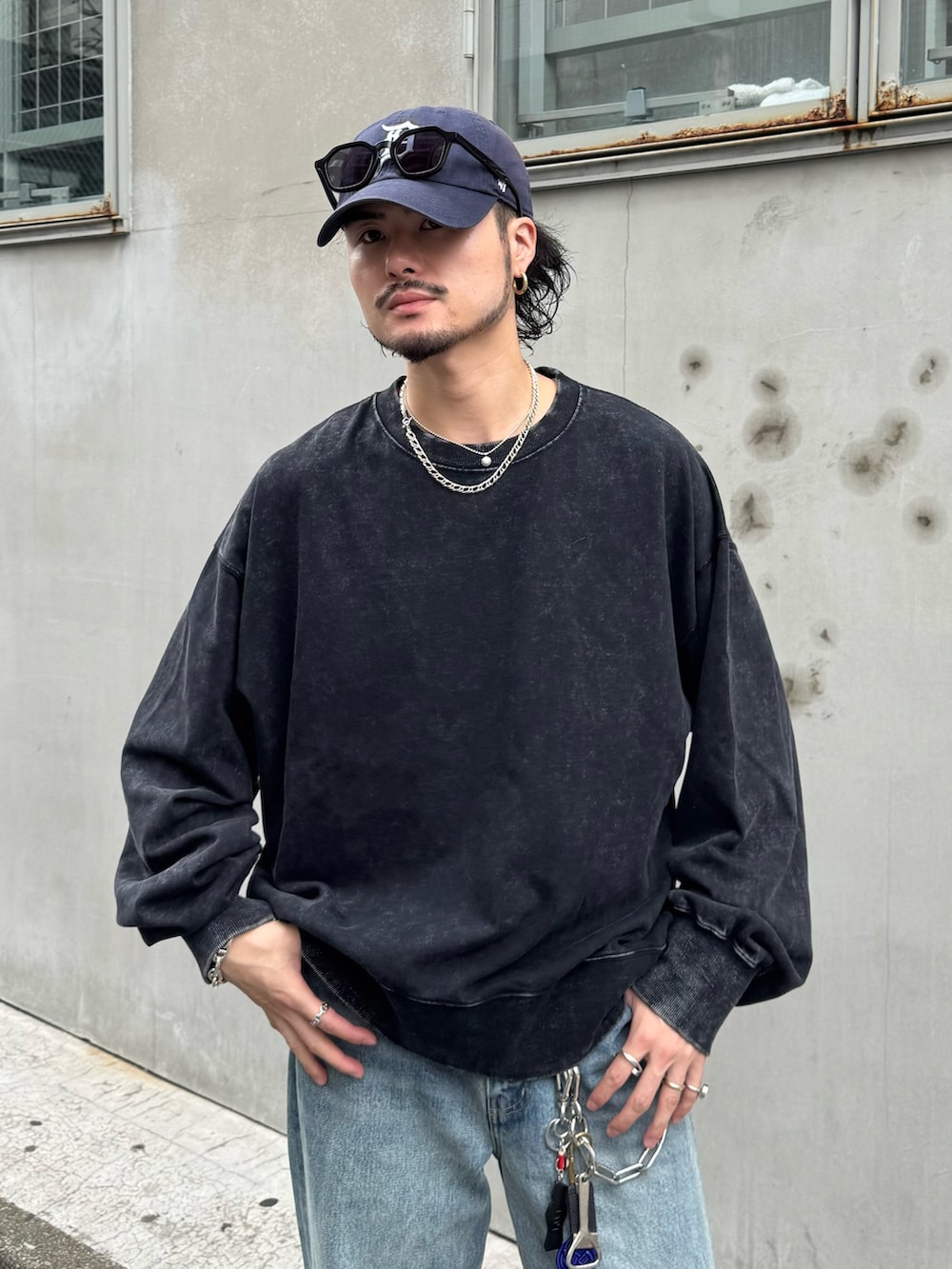 ブラック系のスウェット、ブルー系のデニムパンツを着用したメンズの夏コーディネートの3枚目の写真