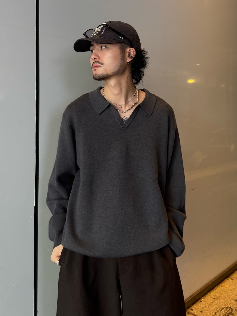 グレー系のニット/セーター、グレー系のスラックスを着用したメンズの秋コーディネートの4枚目の写真