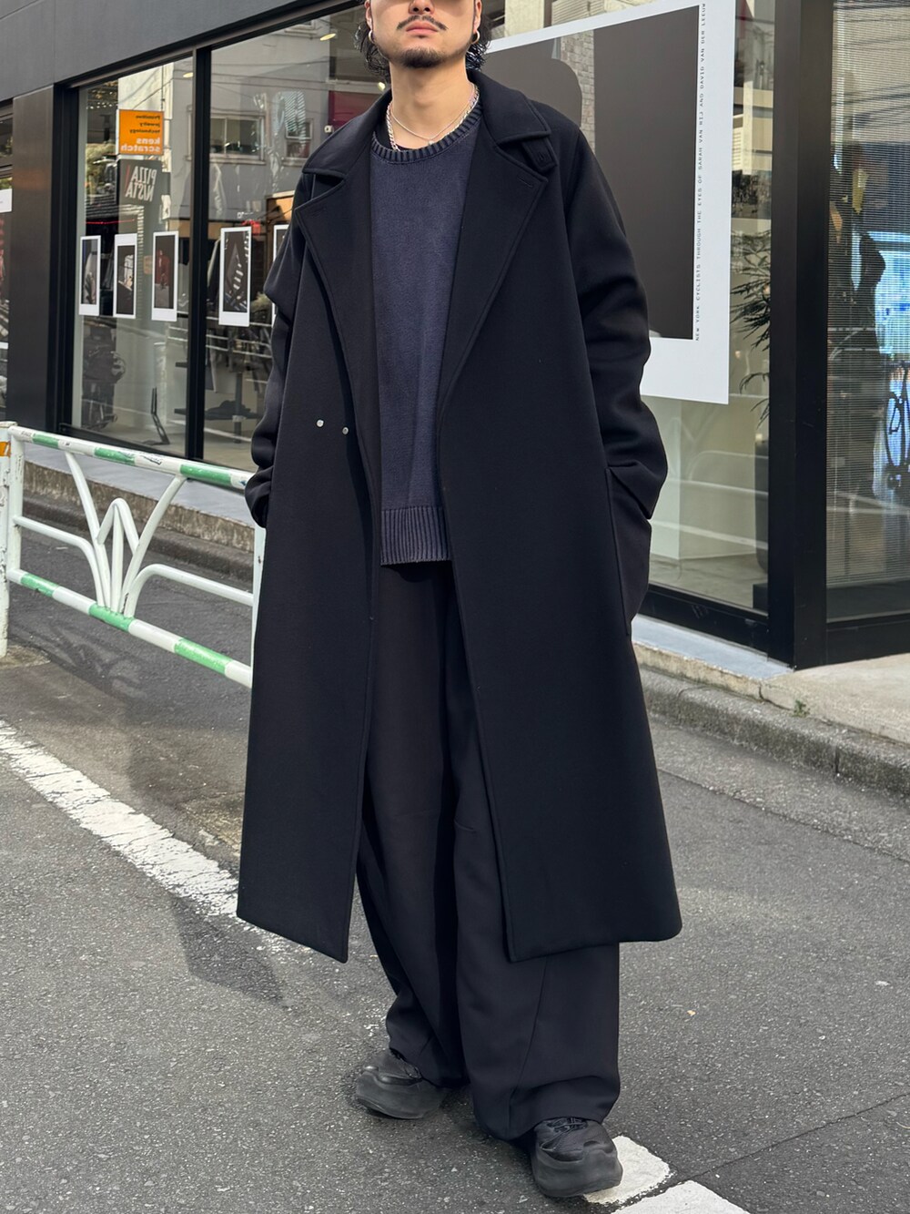 ブラック系のその他アウター、ブルー系のニット/セーター、ブラック系のスラックスを着用したメンズの冬コーディネートの4枚目の写真