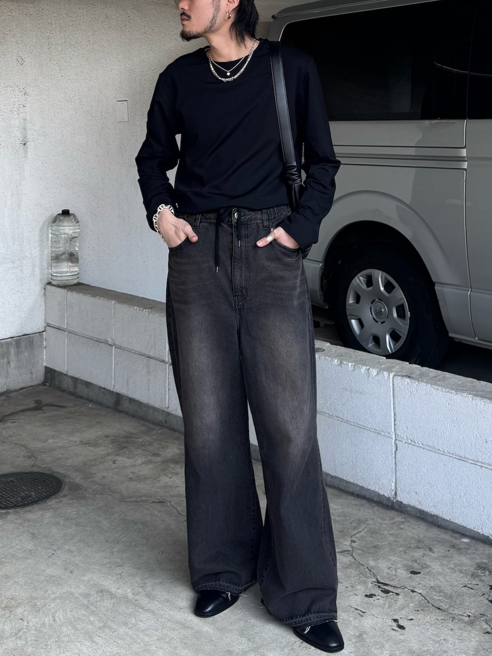 ブラック系のデニムパンツ、ブラック系のその他シューズ、ブラック系のTシャツ/カットソーを着用したメンズの春コーディネートの2枚目の写真