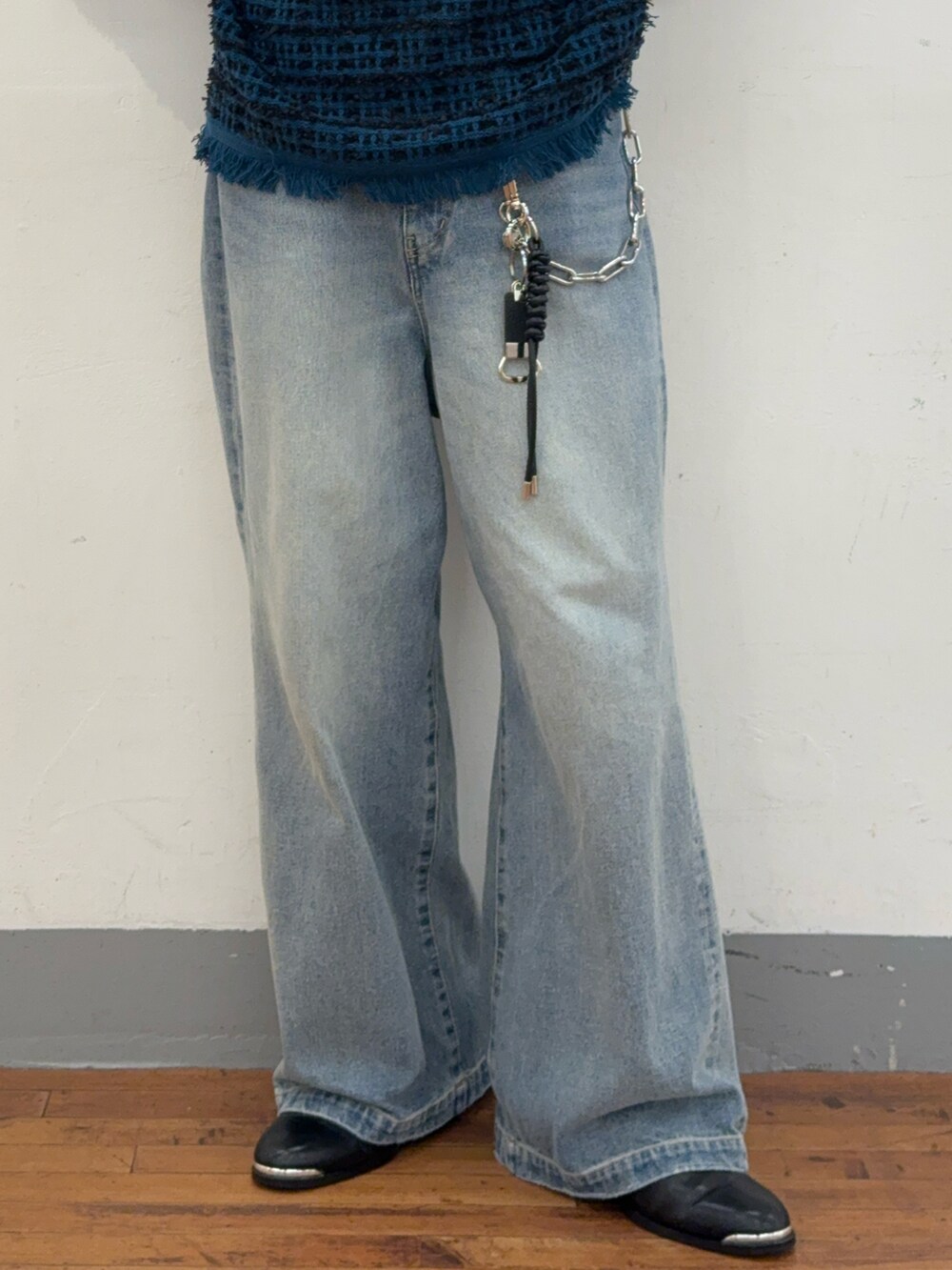 ブルー系のニット/セーター、ブルー系のデニムパンツ、ブラック系のブーツを着用したメンズの秋コーディネートの3枚目の写真