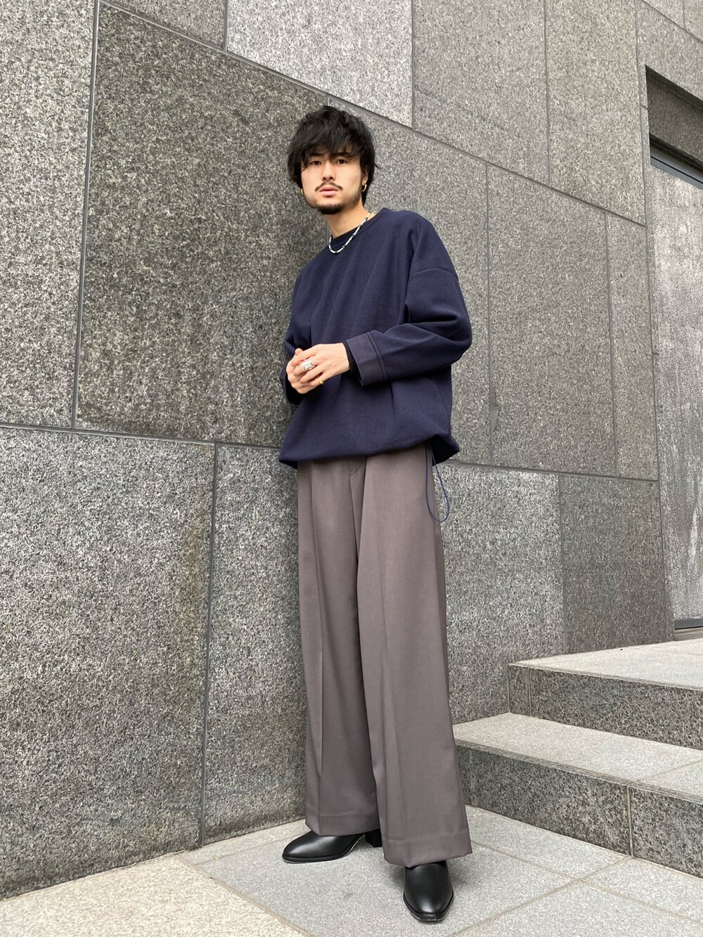 ブルー系のTシャツ/カットソー、グレー系のスラックス、ブラック系のドレスシューズを着用したメンズの冬コーディネートの2枚目の写真