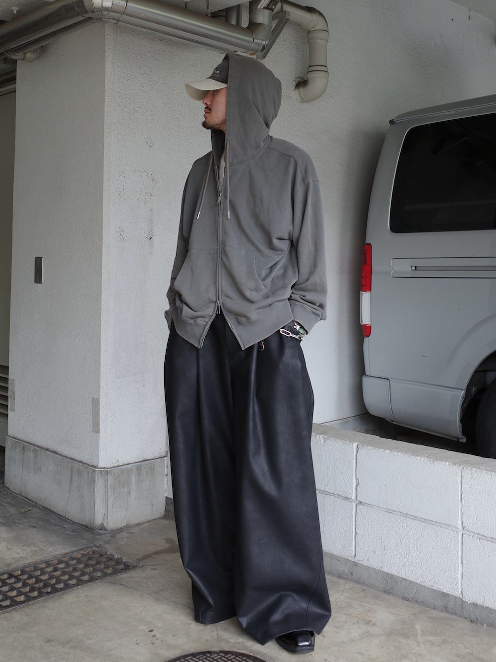 グレー系のパーカー、ブラック系のその他パンツを着用したメンズの秋コーディネートの3枚目の写真