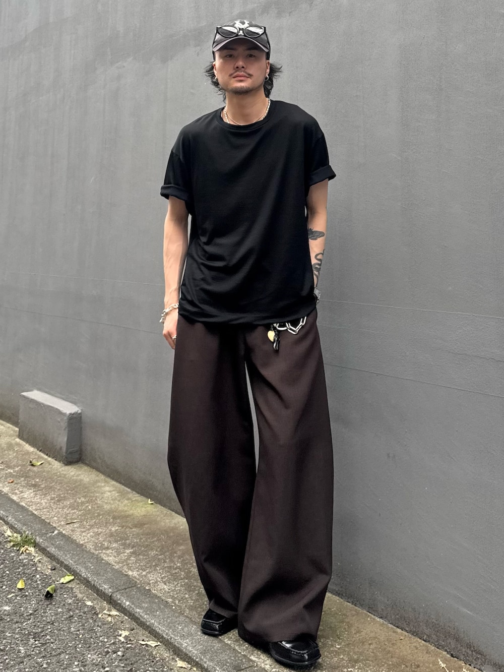 ブラック系のTシャツ/カットソー、グレー系のスラックスを着用したメンズの夏コーディネートの2枚目の写真