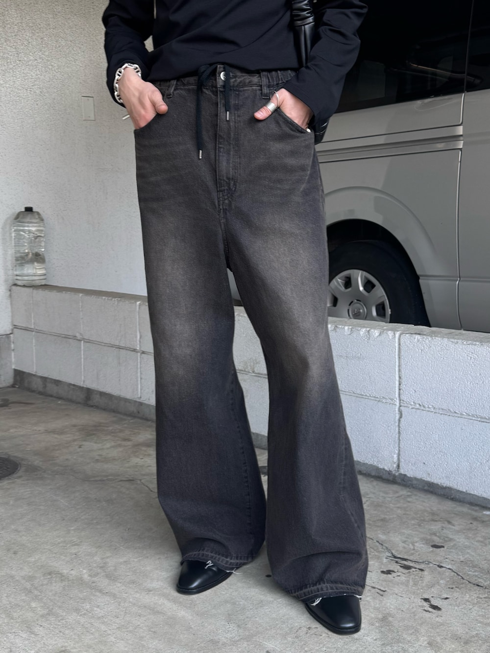 ブラック系のデニムパンツ、ブラック系のその他シューズ、ブラック系のTシャツ/カットソーを着用したメンズの春コーディネートの4枚目の写真