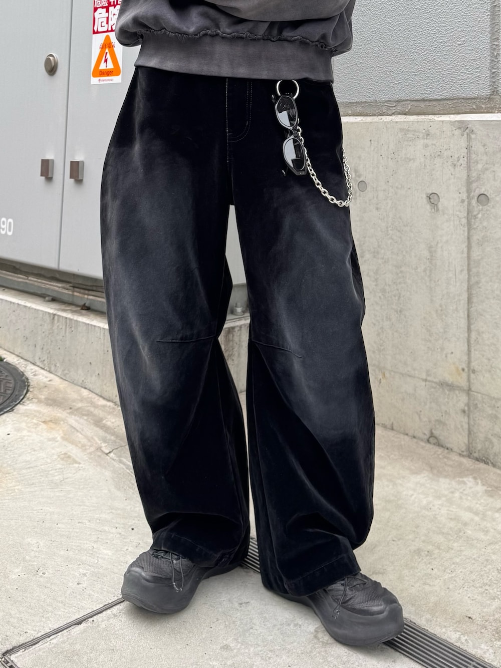 ブラック系のスウェット、ブラック系のデニムパンツ、シルバー系のウォレットチェーンを着用したメンズの春コーディネートの7枚目の写真