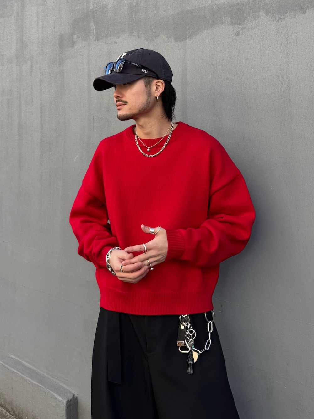 レッド系のニット/セーター、ブラック系のスラックスを着用したメンズの冬コーディネートの5枚目の写真