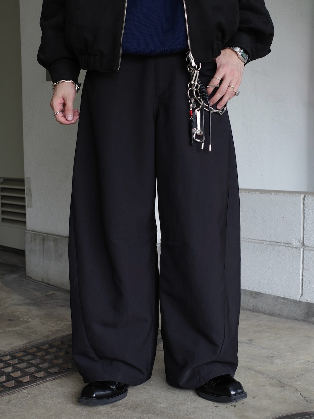 ブラック系のブルゾン、ブルー系のニット/セーター、ブラック系のスラックスを着用したメンズの冬コーディネートの6枚目の写真